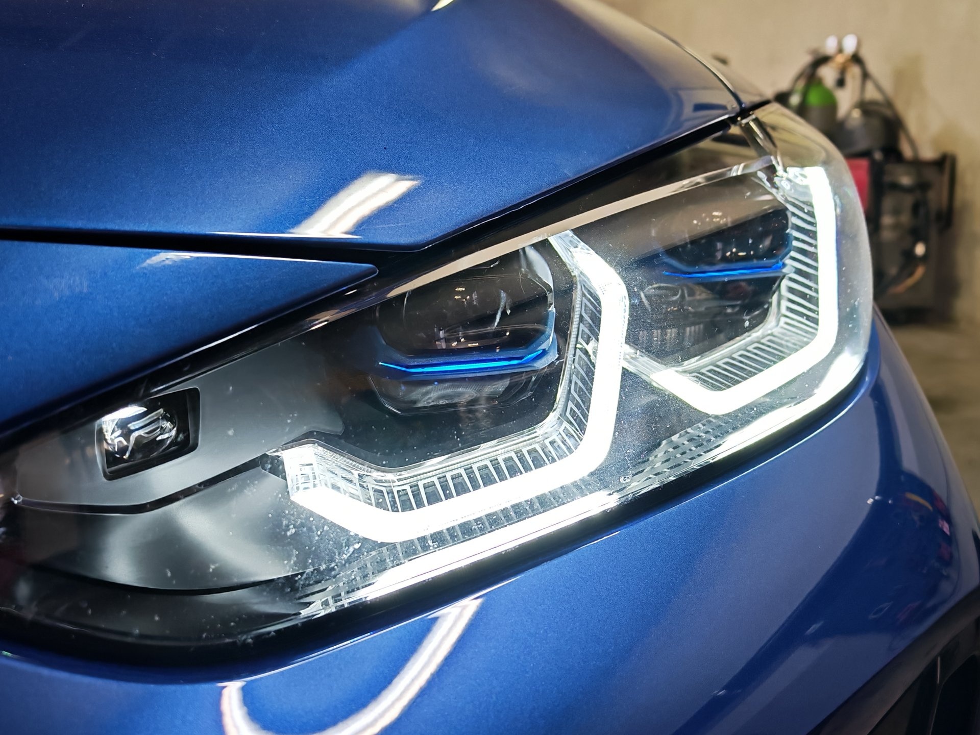 Detalj prednjeg svjetla plavog BMW-a nakon završene obrade
